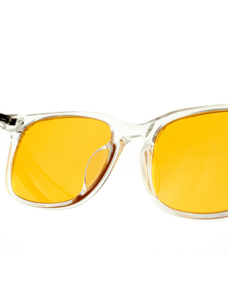 Nahaufnahme einer Brille mit transparentem Gestell und orangegelben Gläsern