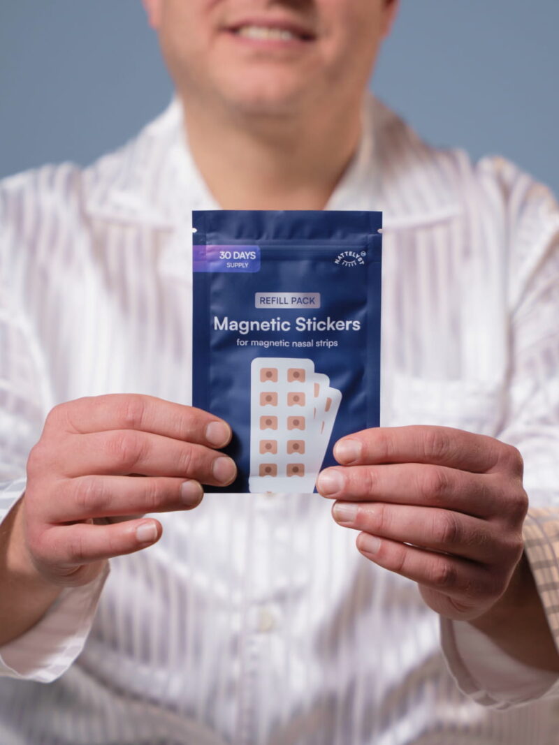 Person hält eine Nachfüllpackung mit magnetischen Nasenpflastern für 30 Tage